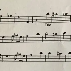 Partition musicale avec des notes et des indications comme "Tous Lentement" et "Trio". Le début de la première ligne montre un exemple d'anacrouse.