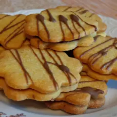 Stos ciastek z marmoladą, ozdobionych czekoladowymi paskami, wygląda apetycznie.