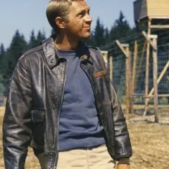 Steve McQueen w skórzanej kurtce, w tle obóz jeniecki.