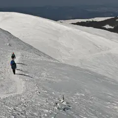 Trzech turystów wędruje po ośnieżonym zboczu. Piękna tarnica zimą, krajobraz zapiera dech w piersiach.
