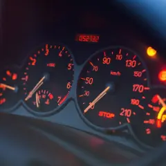 Deska rozdzielcza samochodu z podświetlanymi na czerwono wskaźnikami. Widoczny obrotomierz, prędkościomierz, wskaźnik paliwa i kontrolki. Czy to EPC?