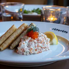 En läcker vegetarisk toast Skagen med rostat bröd, krämig röra med dill och rom, toppad med en dillkvist och citronklyfta.