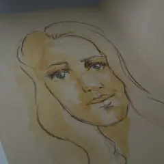 Szkic kobiety z niebieskimi oczami i blond włosami. To może być autoportret, uchwycony w delikatnych barwach.