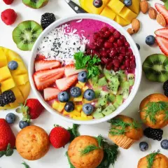 Frukostskål med bär, kiwi, mango och kokos. Muffins och mandlar runt om. En vitaminrik start på dagen!