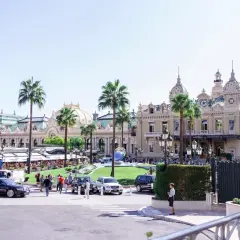 L'iconico Casinò di Montecarlo, un luogo di lusso e divertimento, con palme e auto eleganti. Non una discoteca, ma un simbolo di Montecarlo.