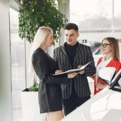 Para omawia umowę leasingu samochodu dla osoby prywatnej z doradcą w salonie.
