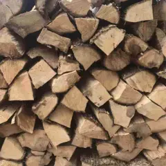 Stos drewna, idealny na czeremcha do kominka. Grube, suche kawałki drewna ułożone jeden na drugim, gotowe do rozpalenia ognia.