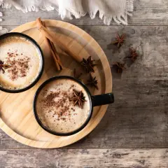 Deux tasses de latte épicé, garnies d'anis étoilé et de cannelle, parfaites pour une recette latte réconfortante.
