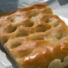 Focaccia genovese, un must per capire cosa mangiare a Genova. Dorata, soffice e profumata, perfetta da gustare in ogni momento.