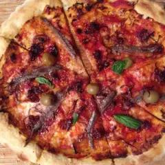 Pizza napolitana con anchoas, aceitunas y albahaca. Una delicia para disfrutar en cualquier momento.