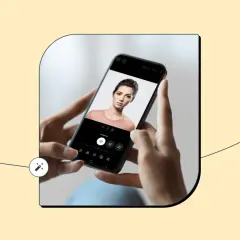 Dłonie trzymają smartfon z portretem kobiety. Na ekranie widać opcje edycji, sugerujące, że to najlepsza aplikacja do robienia zdjęć.