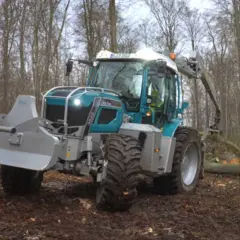 Ein moderner **Traktor mit Kran** im Wald, bereit für die Holzernte.