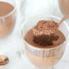 Une cuillère prélève une bouchée aérienne d'une mousse au chocolat onctueuse, parfaite la veille ou le jour même.