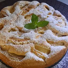 Puszyste, ekspresowe ciasto z jabłkami, posypane cukrem pudrem i ozdobione listkiem mięty. Idealne na szybki deser.