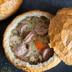 Pyszny żurek z jajkiem i kiełbasą podany w chlebie. Aromatyczne zioła i przyprawy podkreślają smak tradycyjnej polskiej zupy.