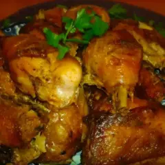 Pyszne, pieczone udka kurczaka w aromatycznej marynacie. Danie ozdobione świeżą natką pietruszki.