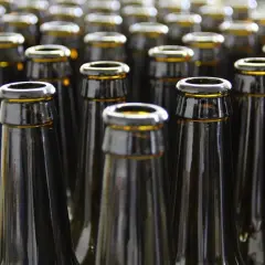 Szklane butelki piwa, czekające na napełnienie. Zastanawiasz się, ile kalorii ma piwo?