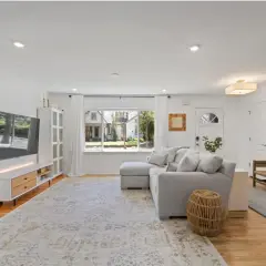 A bright living room with a sectional sofa, TV, and a large rug. This rug is made of polypropylene, so do polypropylene rugs get hot in the sun?