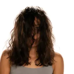 Frau mit dunklem, welligem Haar, das ihr Gesicht verdeckt. Ein Blick auf ihre Schultern und den Ansatz ihres Halses. Vielleicht ist dies das Ergebnis einer neuen locken routine.