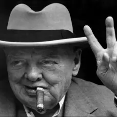 Winston Churchill, chapeau, cigare et signe de victoire. L'alcool et le cigare font partie de son image iconique.