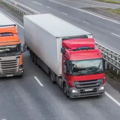 Dwa ciężkie samochody ciężarowe jadące autostradą, przestrzegając dopuszczalny nacisk na oś w Polsce.