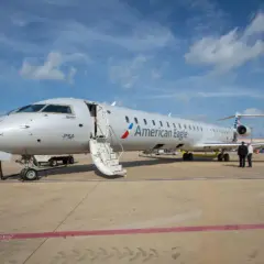 Samolot Canadair Regional Jet 900 linii American Eagle z otwartymi schodami na płycie lotniska.