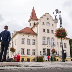 Mężczyzna patrzy na ratusz w Trzebnicy, jedno z wielu urokliwych miejsc i atrakcji tego miasta.