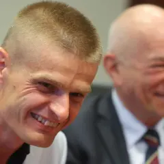 Uśmiechnięty Tomasz Komenda, który otrzymał ogromne odszkodowanie za niesłuszne skazanie, siedzi obok drugiego mężczyzny.