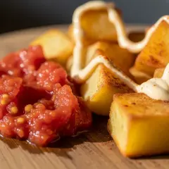 Krispiga potatisbitar med en klick tomatsalsa och en generös sträng aioli. En klassisk portion patatas bravas.