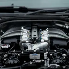 Silnik V8 z polerowanymi elementami i czarnymi przewodami. Słychać metaliczny dźwięk przy dodawaniu gazu, gdy moc jest uwalniana.
