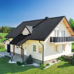 Domy z czarnym dachem, gdzie widać różnicę między tradycyjną dachówką a nowoczesną blachodachówką.