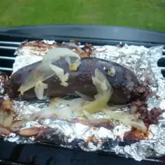 Kaszanka z grilla, soczysta i aromatyczna, pieczona na folii aluminiowej z cebulką. Idealna na letnie wieczory.
