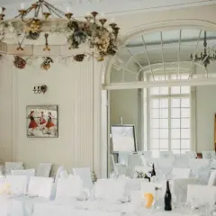Elegancka sala bankietowa w pałacu Grąbkowo, udekorowana kwiatami i przygotowana na przyjęcie.