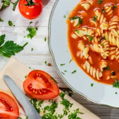 Aksamitna pomidorowa z rosołu z makaronem fusilli, świeżymi pomidorami i natką pietruszki.