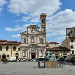 Piazza Ognissanti con la facciata della chiesa di San Salvatore in Ognissanti, una scultura al centro e palazzi circostanti.