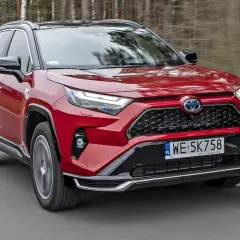 Czerwona Toyota RAV4 Hybrid w ruchu. Sprawdź aktualny toyota rav4 cennik i odkryj możliwości tego SUV-a.
