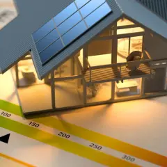 Maquette de maison avec panneaux solaires sur un graphique d'étiquette énergie. Le DPE est essentiel pour savoir que faire.