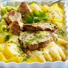 Saftiges Schweinefilet mit Spargel, Kartoffeln und Brokkoli in cremiger Käsesauce, garniert mit Petersilie. Ein köstliches Gericht!