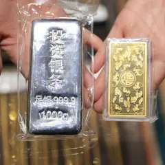 Dwie sztabki metali szlachetnych: duża srebrna 1000g i mała złota, idealne na kurs metali szlachetnych.