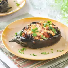 Berenjenas rellenas de carne picada, gratinadas y espolvoreadas con perejil fresco. Un plato casero y delicioso.