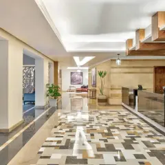 Eleganckie lobby hotelowe z mozaikową podłogą i recepcją. W tle widać wygodne fotele i obrazy, tworząc przyjazną atmosferę dla radisson individuals.