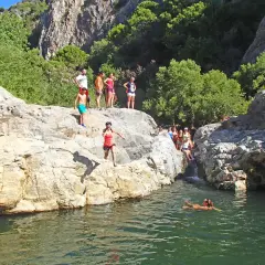 Gente salta a un río en la **Benahavís ruta río**. Un día soleado para disfrutar de la naturaleza y el agua.