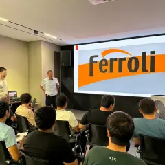 Szkolenie z serwisu Ferroli. Grupa osób słucha prezentacji na tle logo Ferroli. Kontakt do serwisu jest kluczowy.