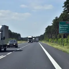 Droga ekspresowa jednojezdniowa S10 wśród lasu. Samochody i ciężarówki jadą w kierunku Nieszawki, Bydgoszczy, Szczecina i Lubieszyna.