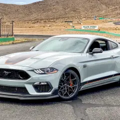 Jasnoszary Ford Mustang Mach 1 z pomarańczowymi akcentami na torze wyścigowym Willow Springs.