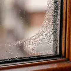 Krople wody na zaparowanym drewnianym oknie.