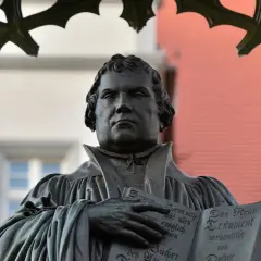 Bronzestatue von Martin Luther, der auf der Wartburg das Neue Testament hält.