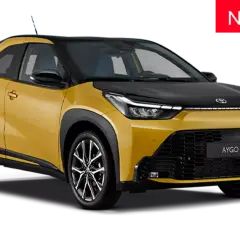 Żółto-czarny samochód Toyota Aygo X z napisem "NOWOŚĆ" na czerwonym tle.