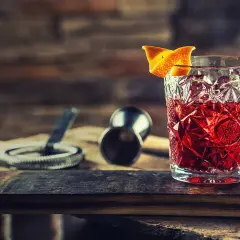 En klassisk negroni drink med apelsinskal, redo att avnjutas.