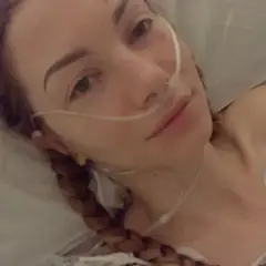 Młoda kobieta z zespołem Ehlersa-Danlosa w szpitalnym łóżku, z rurką tlenową przy nosie. Jej twarz jest blada, a oczy lekko zmęczone.